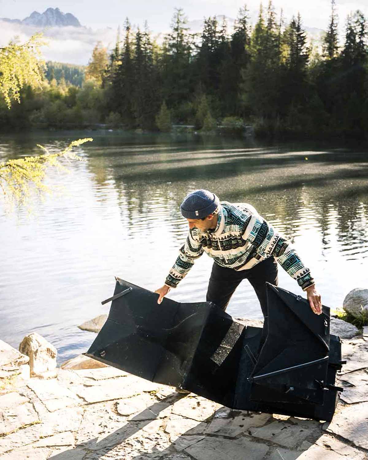 Mann faltet sein Kajak am Fluss
